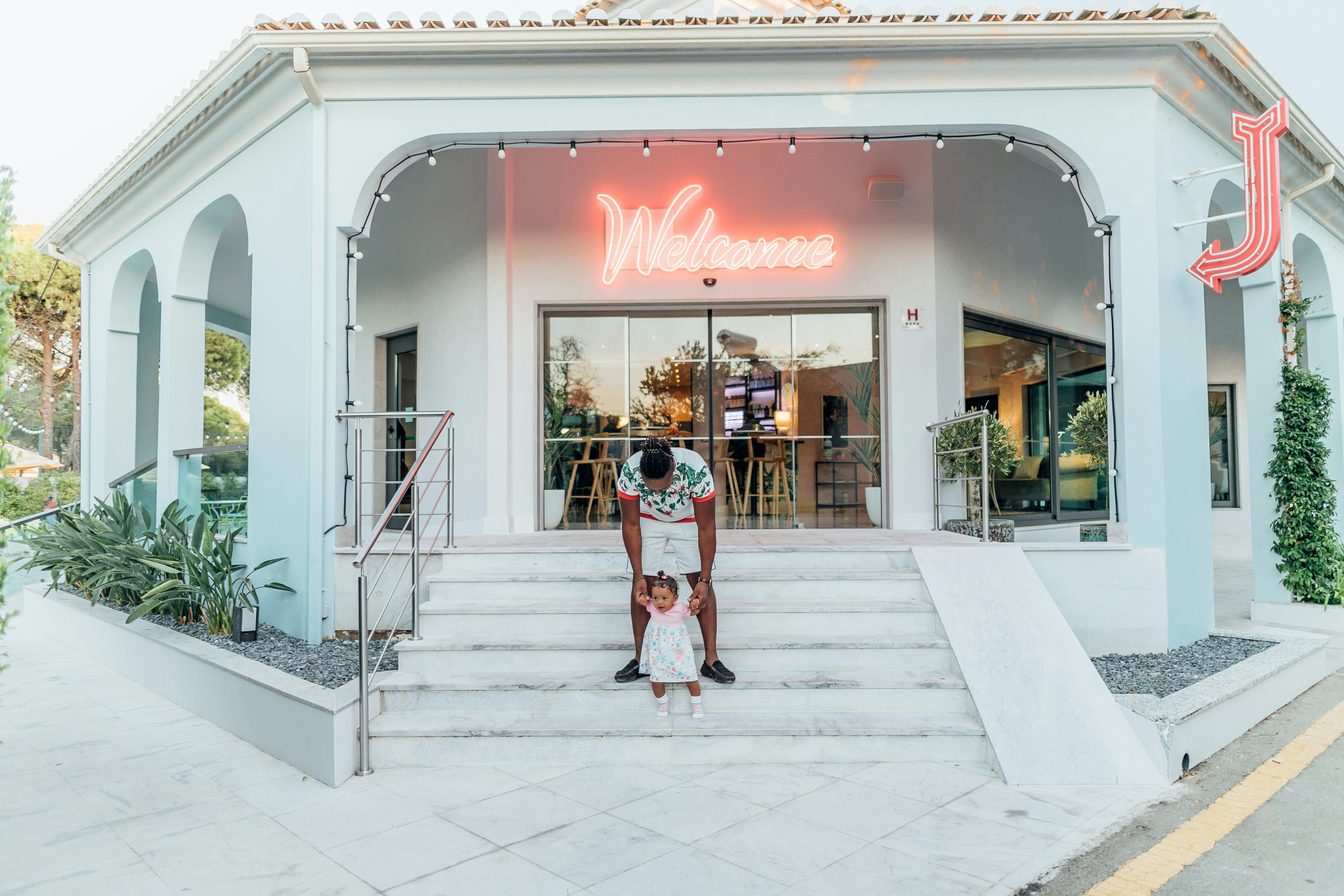 man holding baby in front of restaurant